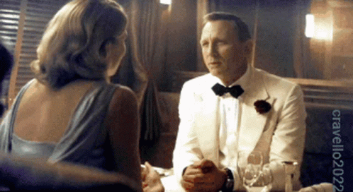 Man In Tuxedo Talking To Woman In Blue Dress GIF