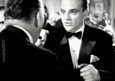 Man in Tuxedo Talks to Another Man in Black and White Photo