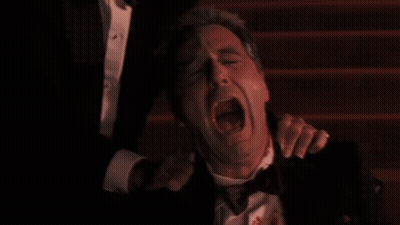 Man In Tuxedo With Blood Being Held GIF