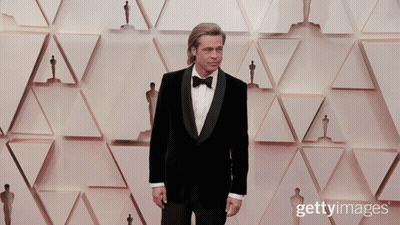 Man In Tuxedo With Oscar Statues GIF