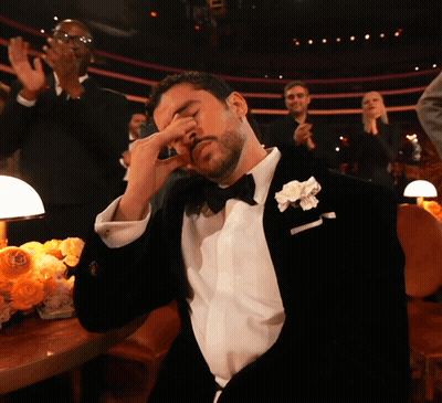 Man In Tuxedo With White Flower Covering Eyes GIF