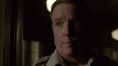 Man In Uniform Standing In Dark Room GIF