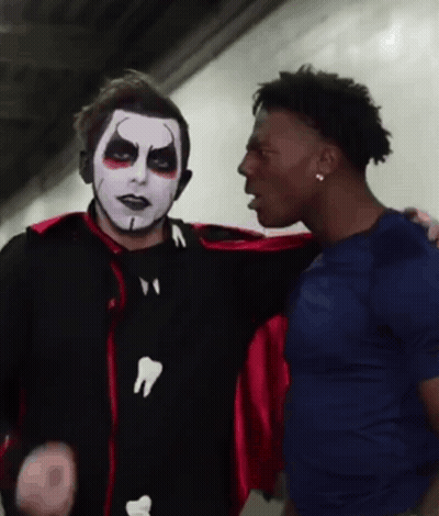 Man In Vampire Costume Talking To Man In Blue Shirt GIF