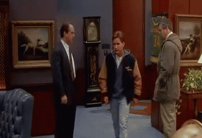 Man in Varsity Jacket Talking to Two Men