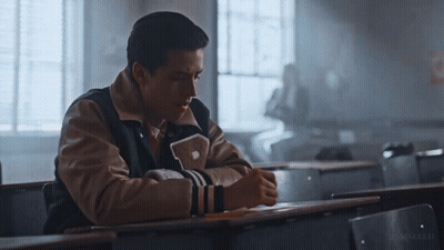 Man In Varsity Jacket With Letter P Sitting At Desk GIF