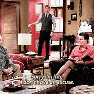 Man In Vest And Tie Talking To Two Men On Couch GIF