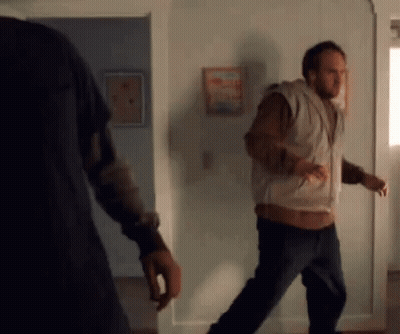 Man In Vest Walking Through Doorway GIF