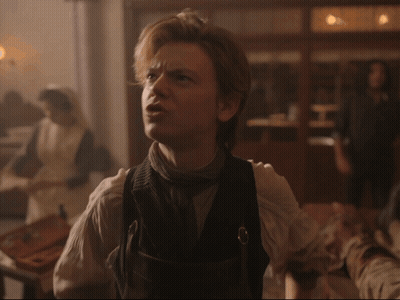 Man In Vest With Woman In White Dress Behind Him GIF