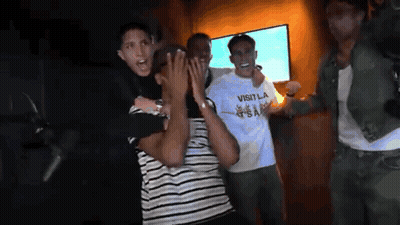 Man In Visitla Shirt Held By Another Man GIF