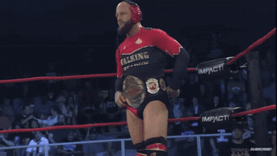 Man In Walking Weapons Shirt Holding Wrestling Belt GIF