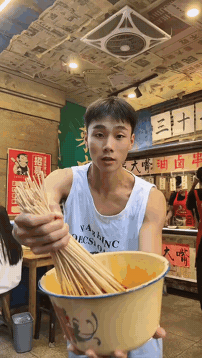 Man In Washington Tank Top Holding Bowl Of Sticks GIF