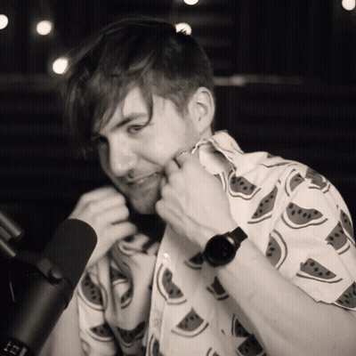 Man In Watermelon Shirt Adjusting Collar At Microphone GIF
