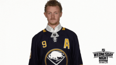Man In Wednesday Night Live Jersey Holding Hockey Puck GIF