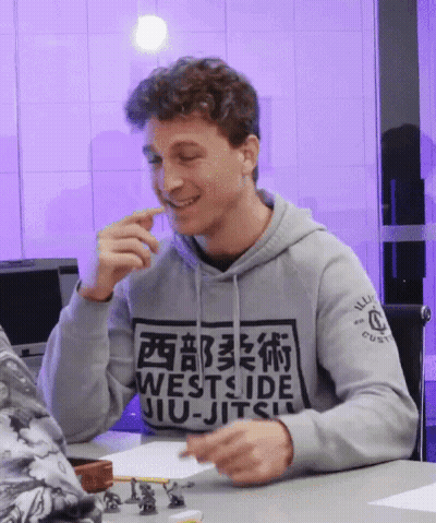 Man In Westside Jiu-Jitsu Hoodie Smiling At Table GIF