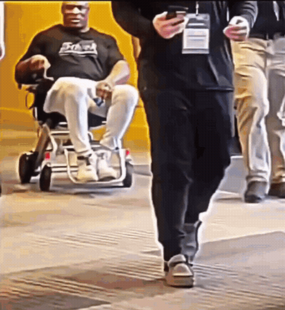 Man In Wheelchair Being Pushed GIF