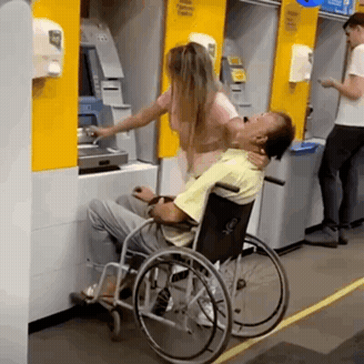 Man In Wheelchair Helped By Woman At ATM GIF