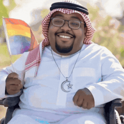 Man In Wheelchair Holding Rainbow Flag GIF