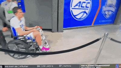 Man In Wheelchair Playing Video Game Under ACC Banner GIF