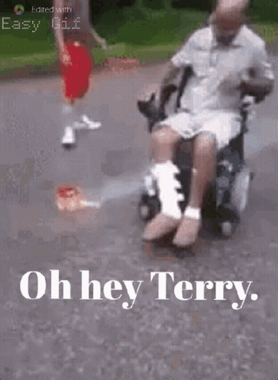 Man In Wheelchair With Leg Bandage Pushed By Another GIF