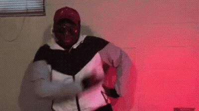 Man In White And Black Jacket Dancing In Red Lights GIF