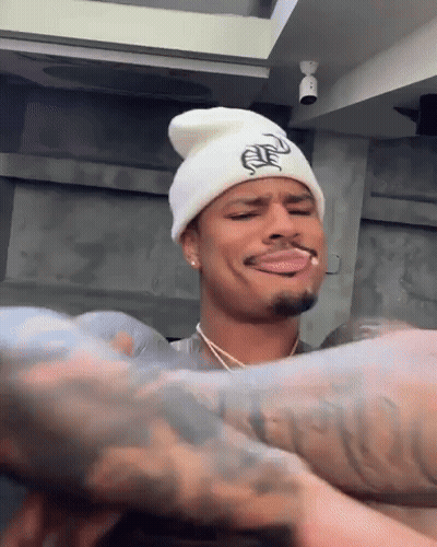 Man In White Beanie Smoking Cigarette Making Face GIF