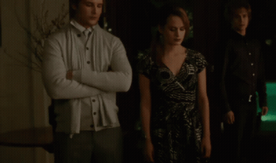 Man In White Cardigan Next To Woman In Dress GIF