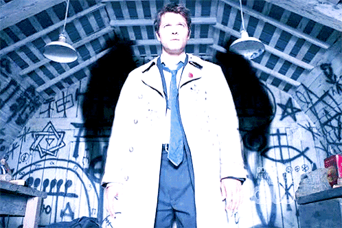 Man In White Coat And Tie Standing In Front Of Graffiti Wall GIF