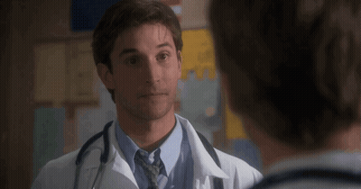 Man In White Coat And Tie Talking To Another Man GIF