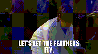 Man In White Coat Kneeling Saying Let's Let The Feathers Fly GIF