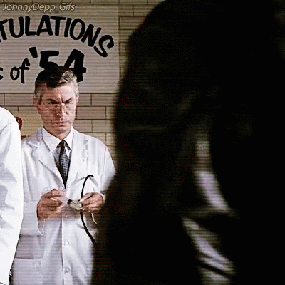 Man In White Coat Standing In Front Of Sign Saying Tulations GIF
