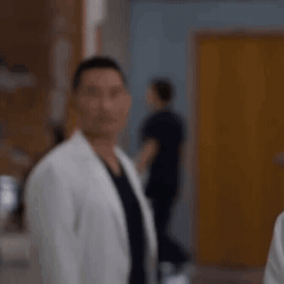 Man In White Coat Standing In Hospital Hallway GIF