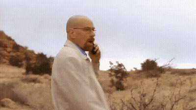 Man In White Coat Talking On Cell Phone In Desert GIF