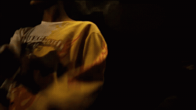 Man In White Coca Cola Shirt In Dark Room GIF