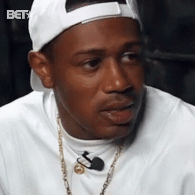 Man In White Hat And Gold Chain Talking To Microphone GIF