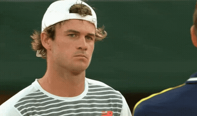 Man In White Hat And New Balance Shirt Looks At Another Man GIF