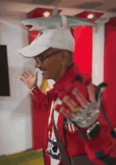 Man In White Hat And Red Jacket Holding Shark Toy On Head GIF