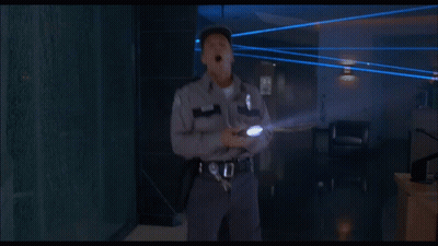 Man In White Hat Walking In Dark Room With Blue Lights GIF