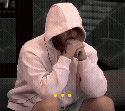 Man In White Hoodie Sitting On Couch With Hands Folded GIF