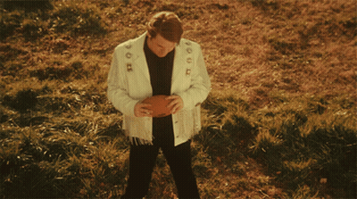 Man In White Jacket Holding Football With Number 1 GIF