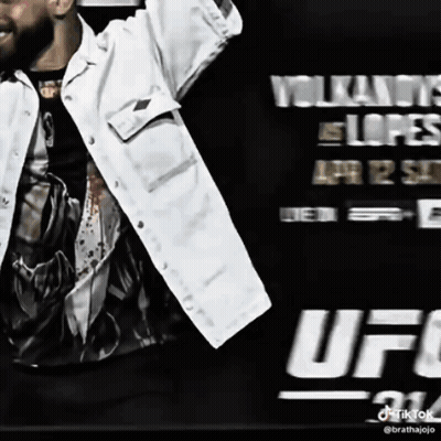 Man In White Jacket In Front Of UFC Sign GIF