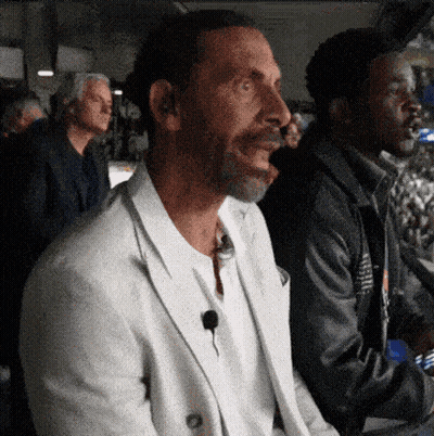 Man In White Jacket With Microphone In Ear GIF