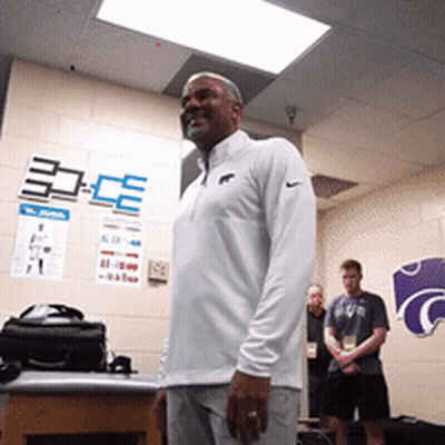 Man In White Nike Shirt In Front Of K Wall GIF