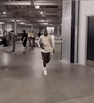Man In White Nike Sweatshirt Running In Hallway GIF