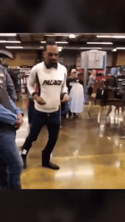 Man In White Palace Sweater Walking Through Store GIF