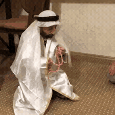 Man In White Robe And Turban Kneeling With Rosary GIF
