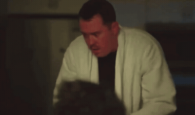 Man In White Robe Holding Gun In Dark Room GIF