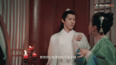 Man In White Robe Next To Woman In Green GIF