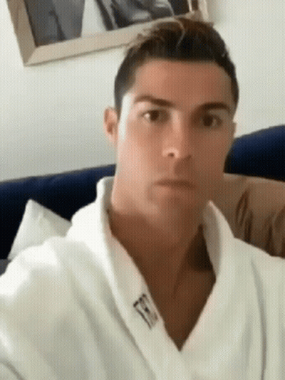 Man In White Robe Sitting On Couch Looking At Camera GIF