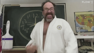 Man In White Robe Standing Before Blackboard GIF