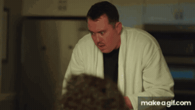 Man In White Robe Standing In Front Of Microwave GIF